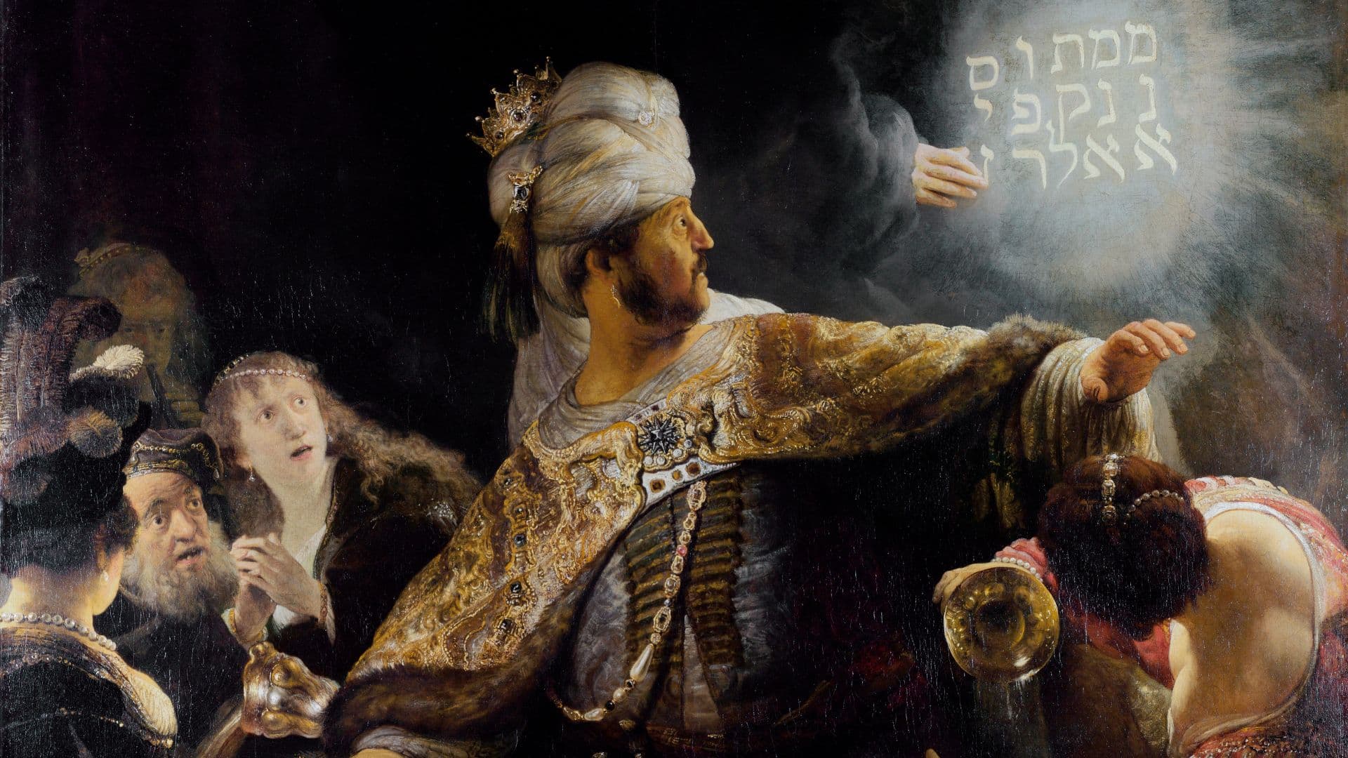 Belsasar y los invitados a su banquete se maravillan ante una mano que escribe un mensaje en una pared en "El banquete de Belsasar" de Rembrandt, una representación de una historia del libro de Daniel en el Antiguo Testamento. Imagen de dominio público